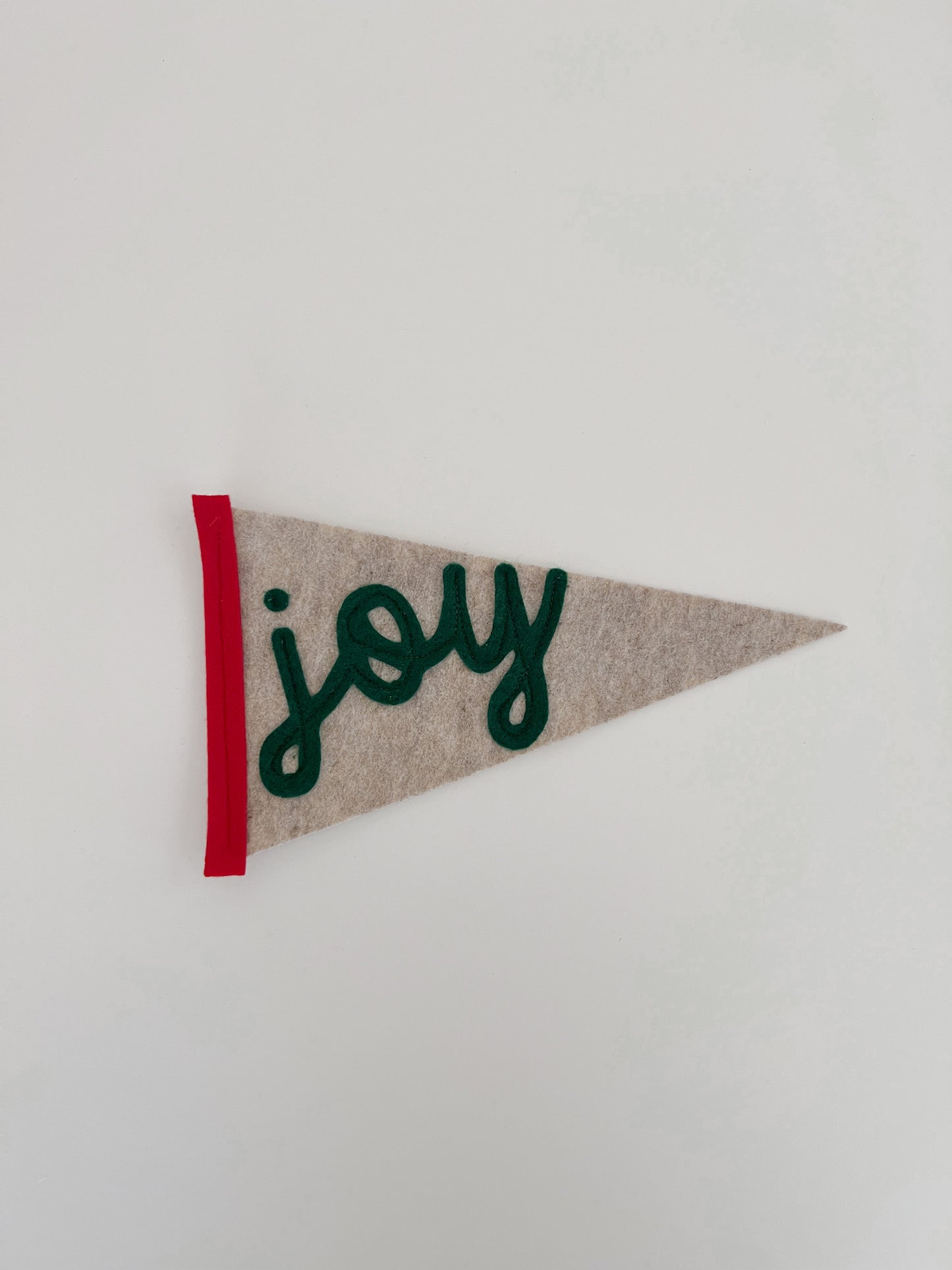 Pennant with a sand background, red siding and Joy text 